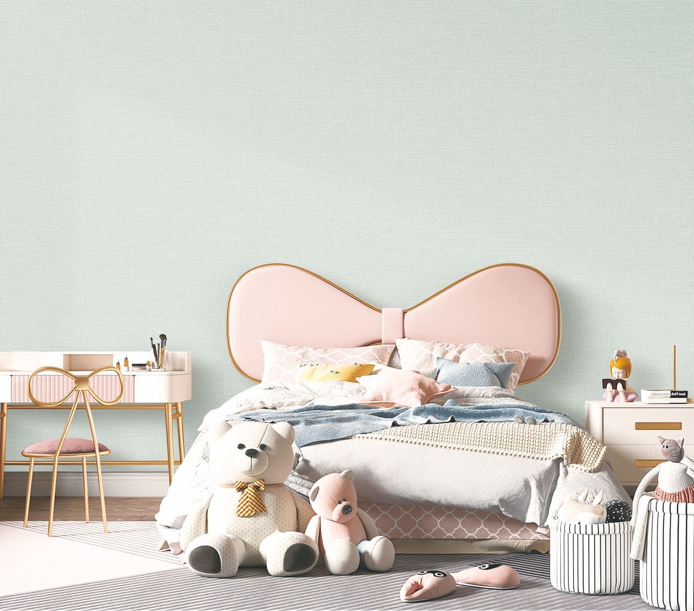 Quarto infantil com papel de parede verde claro, cabeceira em formato de laco rosa e bichos de pelucia