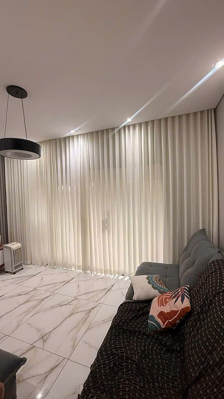 Vídeo percorrendo um quarto com cortina de voil branco ao lado de parede ripada cinza