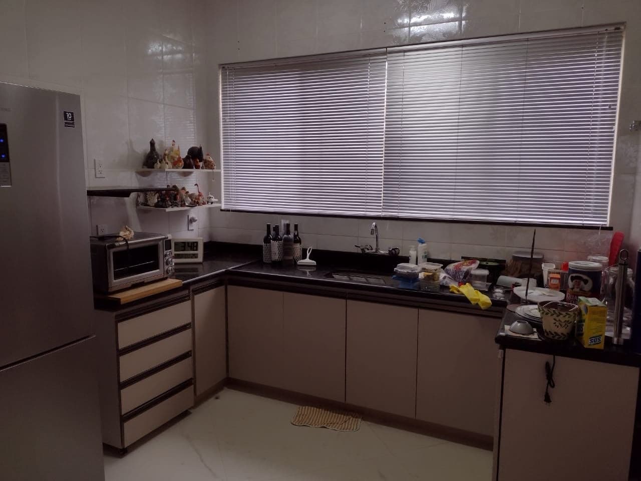 Cozinha com persiana horizontal de alumínio na janela acima da pia
